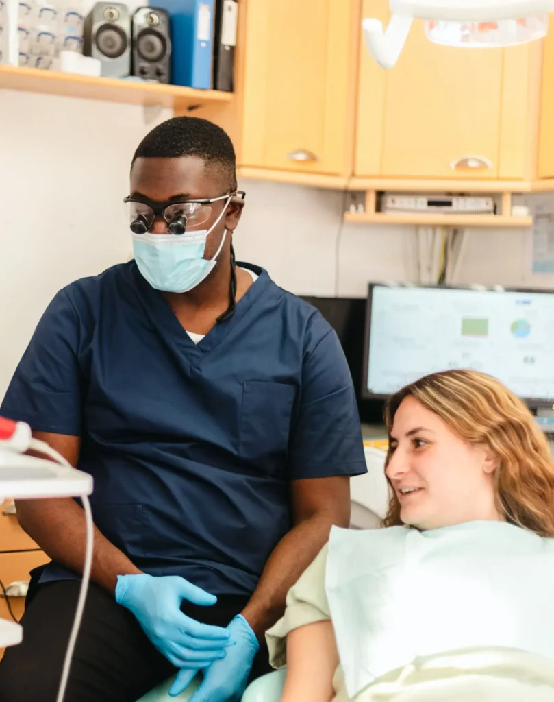 Dentist wearing protective gear during patient examination.