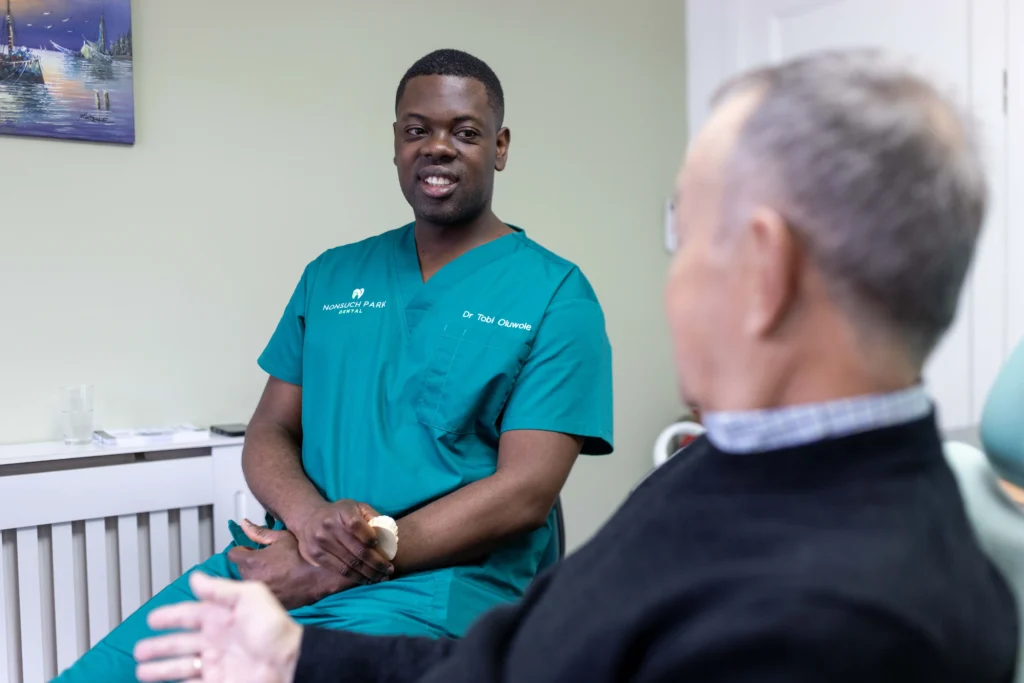 Dr Tobi Oluwole engaging in a dental consultation with a patient.